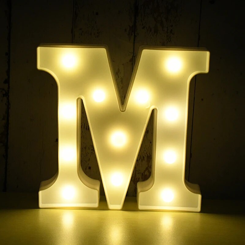 Capital letter M nightlamp illuminated by yellow LED's on a black background