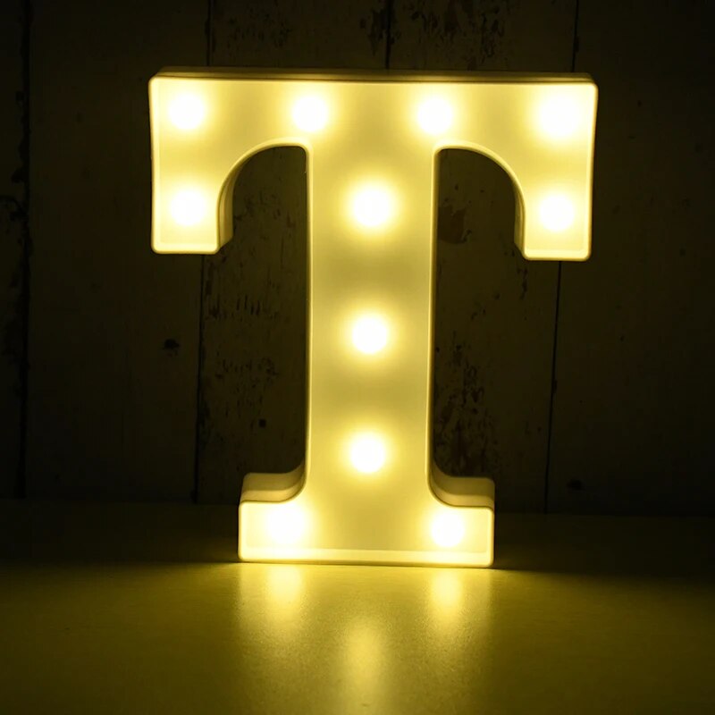 Capital letter T nightlamp illuminated by yellow LED's on a black background