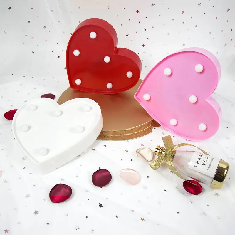 One pink, one red, and one white nighgtlamp hearts nonilluminated on a white background