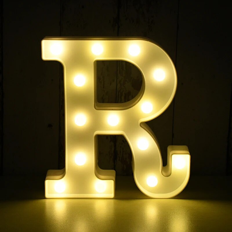 Capital letter R nightlamp illuminated by yellow LED's on a black background