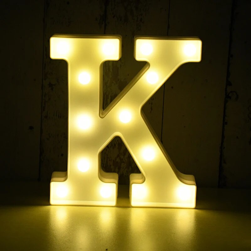 Capital letter K nightlamp illuminated by yellow LED's on a black background