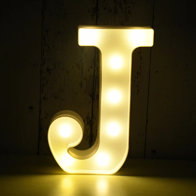 Capital letter J nightlamp illuminated by yellow LED's on a black background