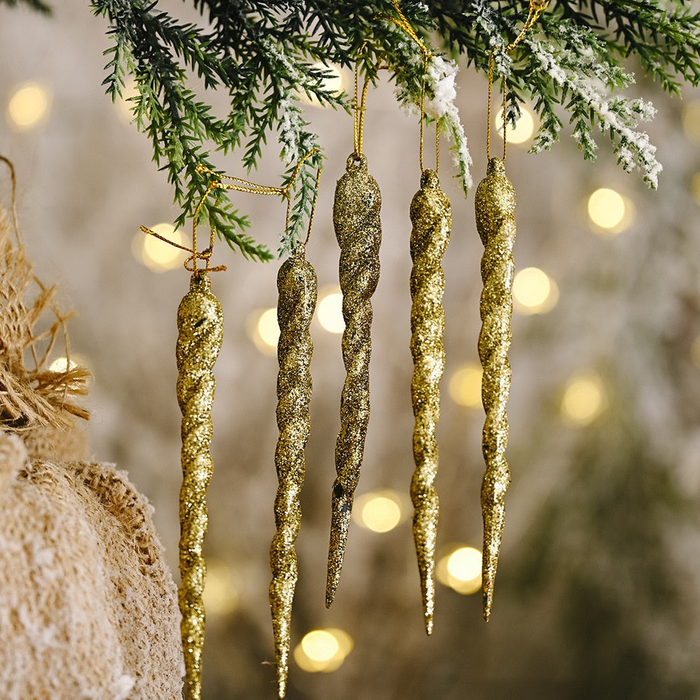 Close up of 5 bronze icicle ornaments with 11 yellow Christmas tree lights on green Christmas tree