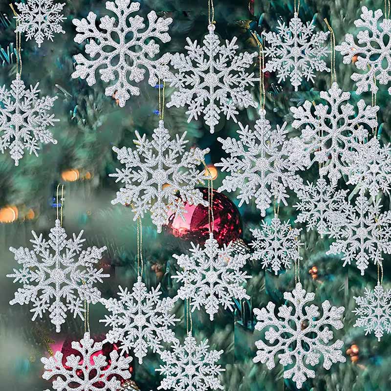 Close up of sixteen opaque snowflake ornaments on green Christmas tree.