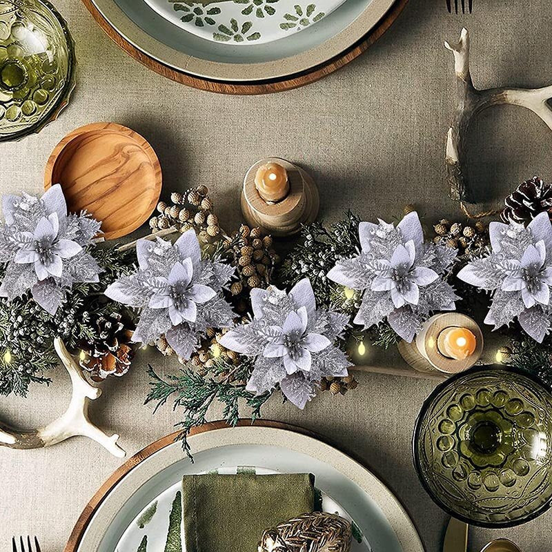 Five fourteen cm light grey artificial Christmas flowers displayed between two white dishes on a dining table.