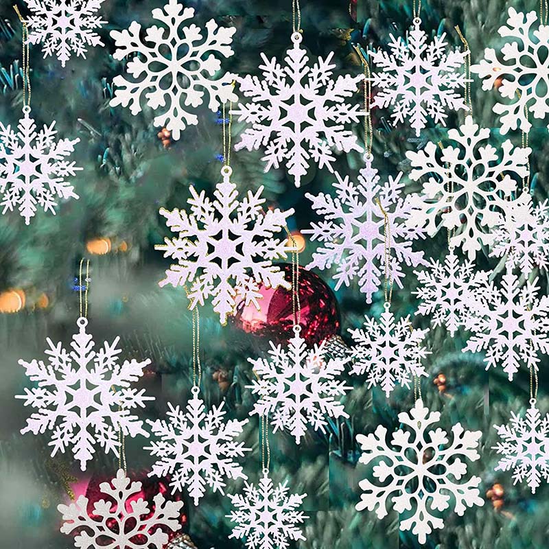 Close up of sixteen opaque snowflake ornaments on green Christmas tree.