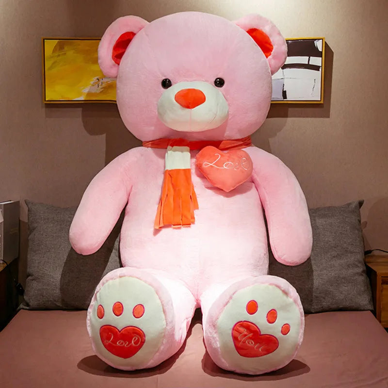  Large pink teddy bear wearing red scarf with red ears, nose and bottom paw prints