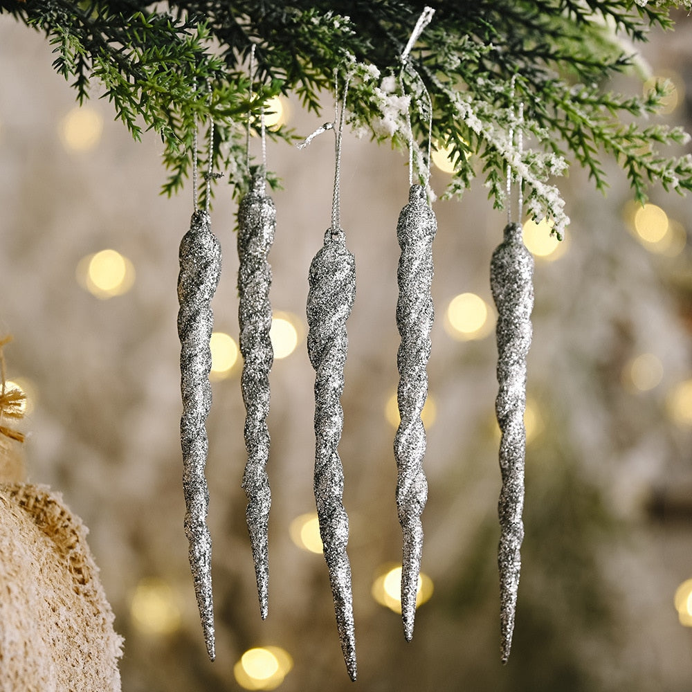 Close up of 5 grey icicle ornaments with 11 yellow Christmas tree lights on green Christmas tree