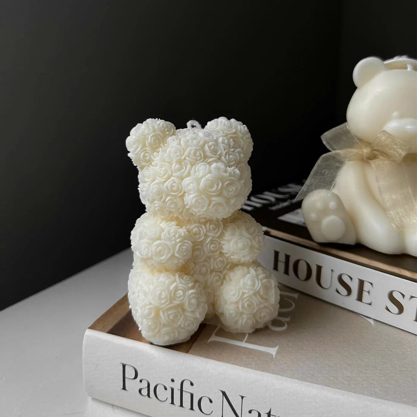  One white chocolate molded bears on white table with black background