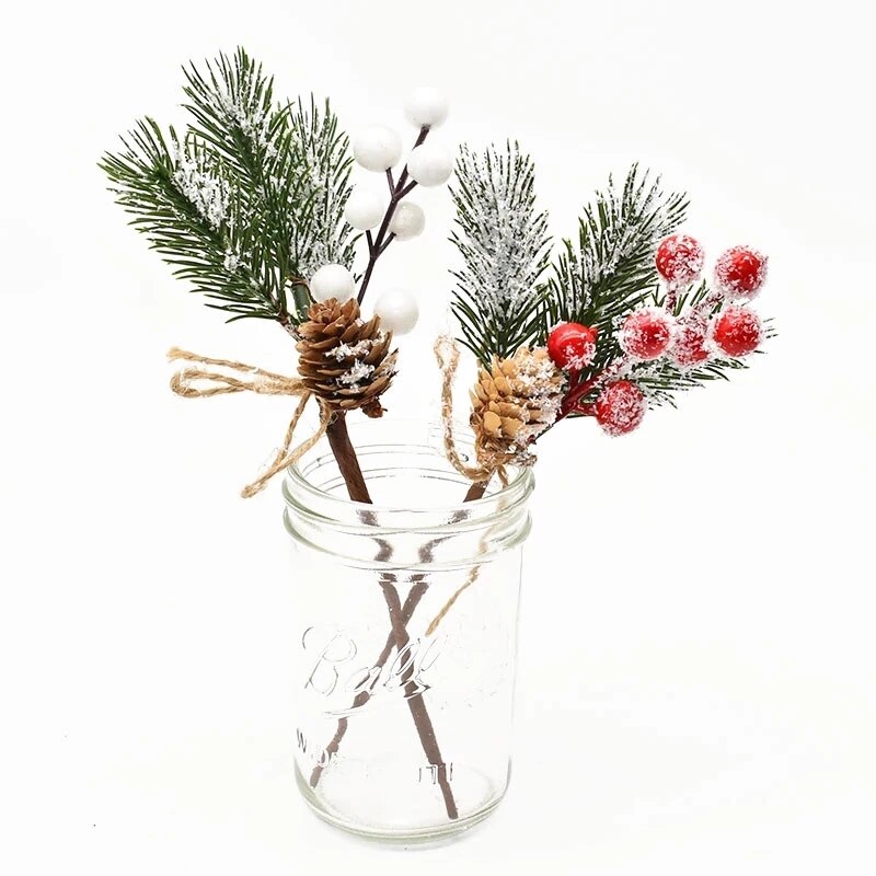 One 22cm by 7.5cm artificial wreathe/garland addition with 3 snowdusted evergreen leaves, a light brown pine cone with red berries and one of the same pieces with white berries placed side by side in a clear jar on a white background.